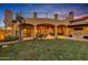 Covered patio with spiral staircase, outdoor kitchen, and lush lawn at 3257 N Piedra Cir, Mesa, AZ 85207