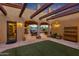 Covered patio and courtyard with a sitting area, lush landscaping, and lighting at 3257 N Piedra Cir, Mesa, AZ 85207