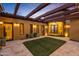 Charming courtyard entry with a pergola, lush landscaping, and lighting at 3257 N Piedra Cir, Mesa, AZ 85207