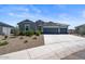 Single-story house with gray exterior, three-car garage, and desert landscaping at 3422 N Cinnabar Pl, Casa Grande, AZ 85122