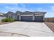 Single-story house with gray exterior, three-car garage, and desert landscaping at 3422 N Cinnabar Pl, Casa Grande, AZ 85122