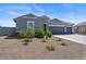 Single-story house with gray exterior, three-car garage, and desert landscaping at 3422 N Cinnabar Pl, Casa Grande, AZ 85122