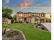 Two-story house with stone accents, landscaped lawn, and a three-car garage at 3829 E Sawtooth Dr, Chandler, AZ 85249