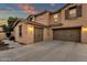 Three-car garage with decorative doors and exterior lighting at 3829 E Sawtooth Dr, Chandler, AZ 85249