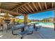 Covered patio area with fireplace and seating near the pool at 4077 S Sabrina Dr # 24, Chandler, AZ 85248