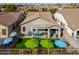 Backyard with patio cover, artificial turf, and umbrellas at 4129 E Cathy Dr, Gilbert, AZ 85296