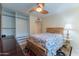 Bedroom with wood bed frame, ceiling fan, and large closet at 4200 N Miller Rd # 121, Scottsdale, AZ 85251