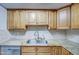 Kitchen boasts granite countertops, double sink, and wood cabinets at 4200 N Miller Rd # 121, Scottsdale, AZ 85251