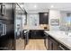 Modern kitchen with dark cabinetry, granite countertops, and stainless steel appliances at 4803 N Woodmere Fairway -- # 2002, Scottsdale, AZ 85251