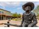 Bronze statue of a cowboy sitting on a fence at 7402 E Carefree Dr # 113, Carefree, AZ 85377