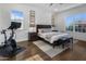 Bright bedroom with queen-size bed, hardwood floors, and a Peloton exercise bike at 8400 E Columbus Ave, Scottsdale, AZ 85251