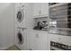 Laundry room with stackable washer and dryer, coffee maker, and wine cooler at 8400 E Columbus Ave, Scottsdale, AZ 85251