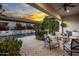 Covered patio with seating area, offering views of the pool and sunset at 8400 E Columbus Ave, Scottsdale, AZ 85251