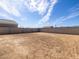 View of a spacious backyard with a block wall and blue skies overhead at 9108 N 174Th Ln, Waddell, AZ 85355