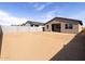 View of a spacious backyard with a block wall and the back of the house with a covered porch at 9108 N 174Th Ln, Waddell, AZ 85355