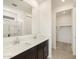 Bright bathroom featuring double sinks and a view of the walk-in closet and shower at 9108 N 174Th Ln, Waddell, AZ 85355