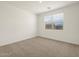 Bright bedroom with neutral carpet, a window with blinds, and a view of the outdoors at 9108 N 174Th Ln, Waddell, AZ 85355