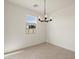 A minimalist dining room with a chandelier, window, and neutral tile floors at 9108 N 174Th Ln, Waddell, AZ 85355