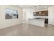 A living room and kitchen with neutral colored tile floors and a view to the outside at 9108 N 174Th Ln, Waddell, AZ 85355