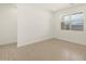 A bright living room with neutral colored tile floors and white walls at 9108 N 174Th Ln, Waddell, AZ 85355