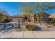 House exterior featuring a two-car garage and mature trees at 9754 E Natal Ave, Mesa, AZ 85209