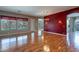 Spacious living room featuring hardwood floors and a dramatic red accent wall at 9754 E Natal Ave, Mesa, AZ 85209