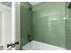 Modern bathroom with green tile shower/tub combo at 10896 E Sahuaro Dr, Scottsdale, AZ 85259