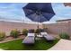 Private backyard oasis with lounge chairs and a large umbrella at 17937 W Cedarwood Ln, Goodyear, AZ 85338