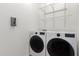 Convenient laundry room with washer, dryer, and shelving at 17937 W Cedarwood Ln, Goodyear, AZ 85338