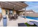 Covered patio with dining area, adjacent to the pool at 17937 W Cedarwood Ln, Goodyear, AZ 85338