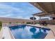 Inviting backyard pool with waterfall feature and covered patio at 17937 W Cedarwood Ln, Goodyear, AZ 85338