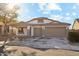 Single-story house with tan exterior, two-car garage, and landscaped front yard at 19912 N Toledo Ave, Maricopa, AZ 85138