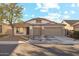 Single-story house with tan exterior, two-car garage, and landscaped front yard at 19912 N Toledo Ave, Maricopa, AZ 85138