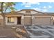 Single-story house with tan exterior, two-car garage, and landscaped front yard at 19912 N Toledo Ave, Maricopa, AZ 85138