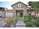 Curb appeal abounds in this charming stone home, featuring a welcoming porch and lush landscaping at 2311 N Park St, Buckeye, AZ 85396