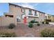 Inviting townhome with a vibrant red door and neutral stucco exterior, complemented by low-maintenance desert landscaping at 2725 E Mine Creek Rd # 1121, Phoenix, AZ 85024