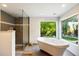 Spa-like bathroom with soaking tub, walk-in shower, and large window at 2856 E Cochise Rd, Phoenix, AZ 85028