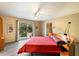 Bright bedroom with red bedding, sliding glass door to patio, and wood floors at 2856 E Cochise Rd, Phoenix, AZ 85028
