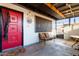 Covered patio with seating, red door, and screen at 5984 W Augusta Ave, Glendale, AZ 85301