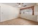 Bedroom features neutral tile flooring and a window with plaid curtains at 7202 W Carol Ave, Peoria, AZ 85345