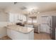 L-shaped kitchen with white cabinets and stainless steel appliances at 7202 W Carol Ave, Peoria, AZ 85345