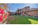 Large backyard with a spacious lawn, brick-paved patio, and a covered seating area at 8280 S Pecan Grove Cir, Tempe, AZ 85284