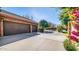 Three-car garage with brown doors and a brick exterior at 8280 S Pecan Grove Cir, Tempe, AZ 85284