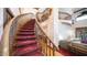 Elegant curved staircase with wood railings and red carpet at 8280 S Pecan Grove Cir, Tempe, AZ 85284