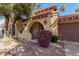 Front entry with arched doorway, wrought iron gate, and purple flowers at 10473 N 87Th Pl, Scottsdale, AZ 85258