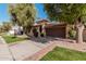 Tan stucco house with brown garage door and nicely landscaped yard at 10473 N 87Th Pl, Scottsdale, AZ 85258