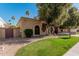 Tan stucco house with brown gate and nicely landscaped yard at 10473 N 87Th Pl, Scottsdale, AZ 85258