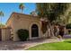 Tan stucco house with brown gate and nicely landscaped yard at 10473 N 87Th Pl, Scottsdale, AZ 85258