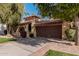 Tan stucco house with brown garage door and nicely landscaped yard at 10473 N 87Th Pl, Scottsdale, AZ 85258