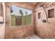 Shower with tile surround and window overlooking courtyard at 10473 N 87Th Pl, Scottsdale, AZ 85258